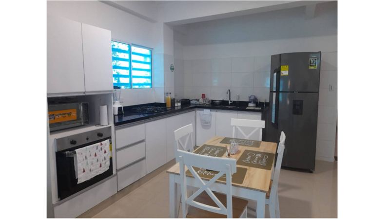 Fully equipped kitchen with oven, fridge and dining area